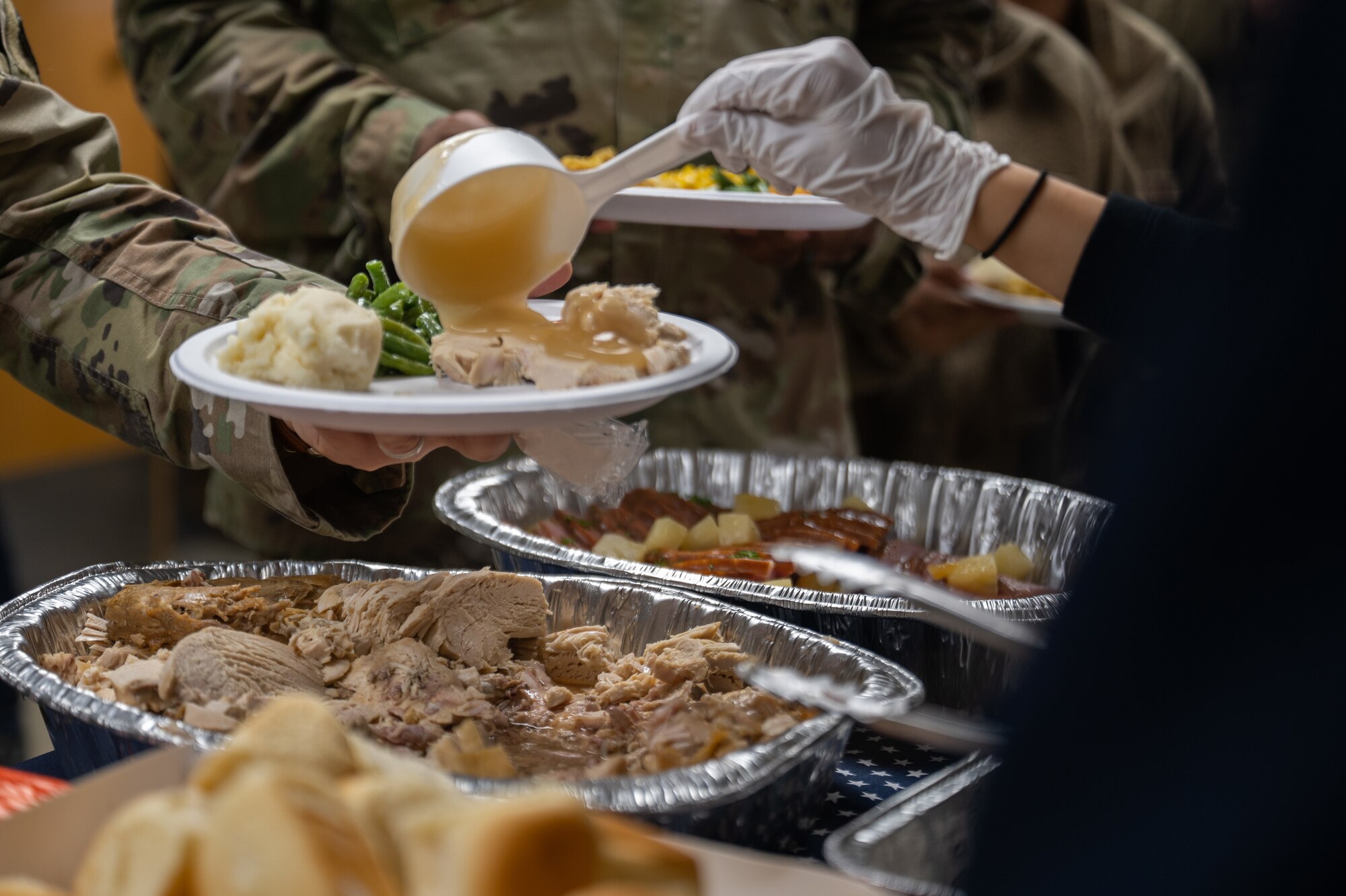 An Airman receives gravy from a USO Osan volunteer