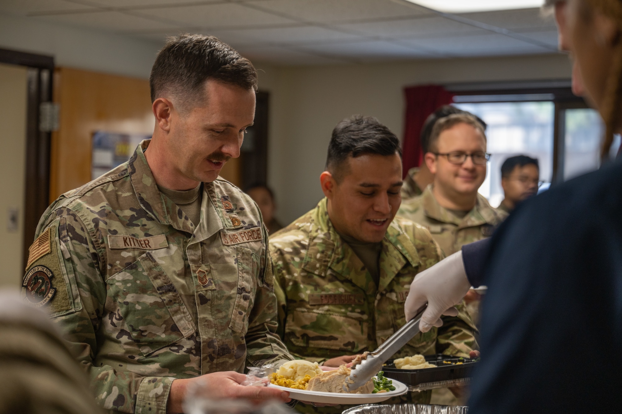 Master Sgt. Howard Kitter, 8th Maintenance Squadron munitions accountable systems officer, receives a plate of food from a USO Osan volunteer