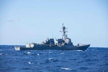 The Arleigh Burke-class guided missile destroyer USS Thomas Hudner (DDG 116) steams alongside the Ticonderoga-class guided missile cruiser USS Normandy (CG 60) while both ships are underway as part of the Ford Carrier Strike Group, March 15, 2023.