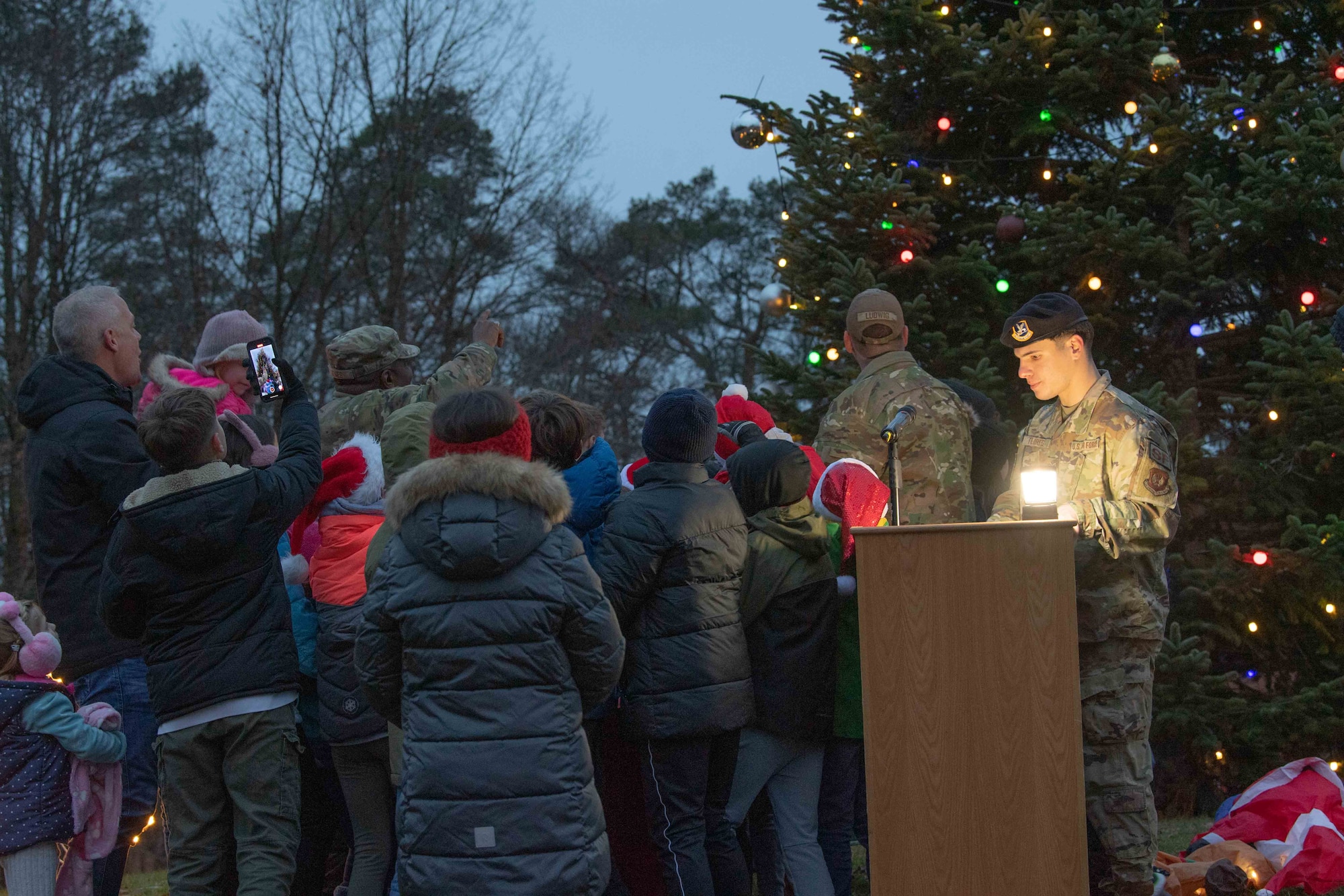 A group of people watch a tree light up