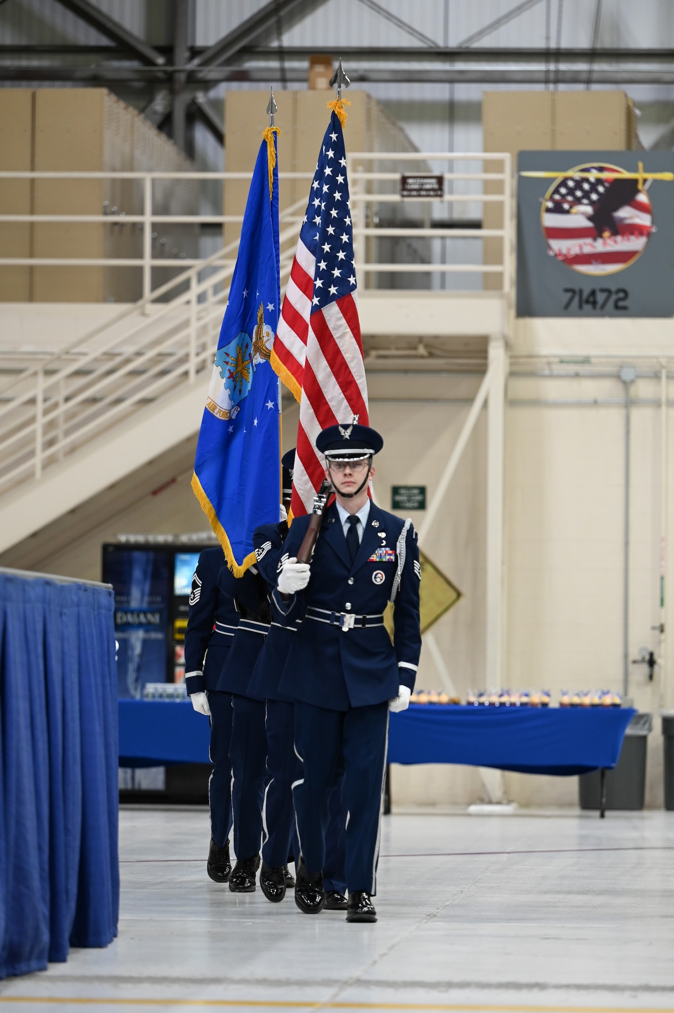 Members of the Grissom Air Reserve Base Honor Guard participate in a change of command ceremony at Grissom Air Reserve Base, marching in the direction of the photo's photographer. The front service member is holding the American flag, others are not visible but the Air Force flag can be seen.