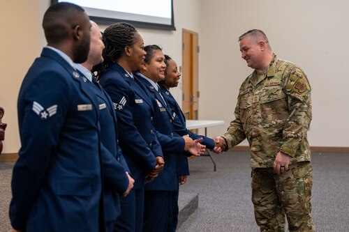 Chief Master Sergeant shaking Airmens' hands.