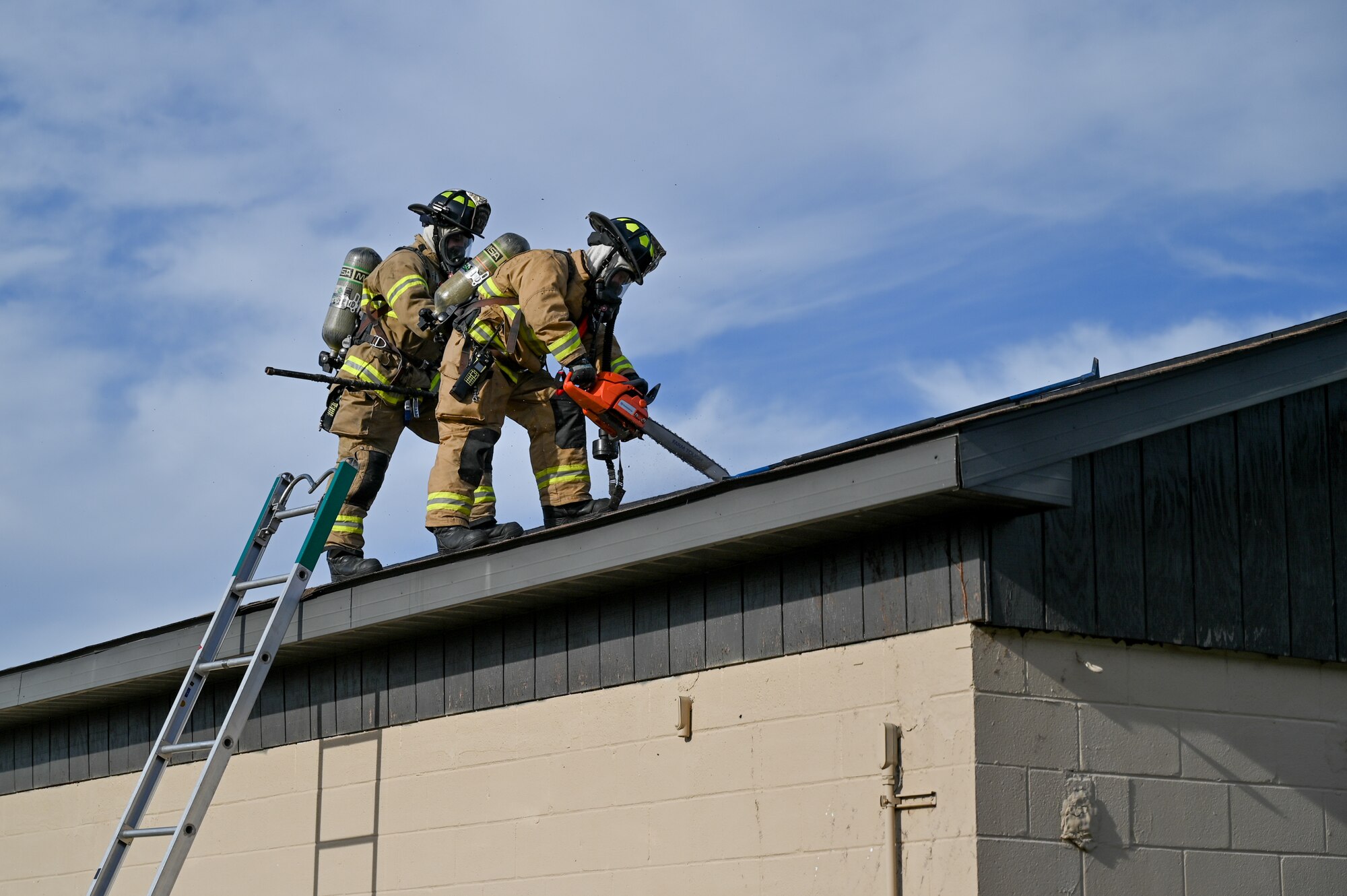 Airmen assigned to the 175th Wing Fire Department saw into the roof of a simulated burning building to inspect for fire hazards during Operation Frosty Strike Nov. 30, 2023, at Martin State Air National Guard Base, Middle River, Md.