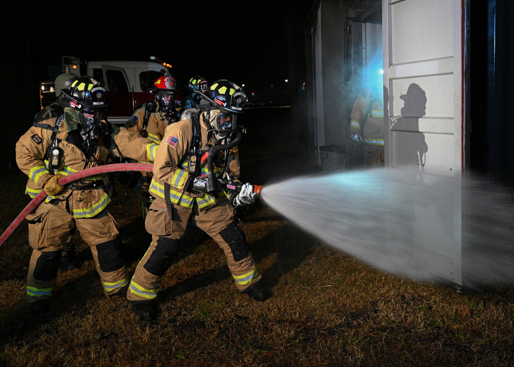 Airmen from the 175th Fire Department, Maryland Air National Guard, spray a simulated burning building during Operation Frosty Strike at Martin State Air National Guard Base, Middle River, Maryland, Dec. 1, 2023.