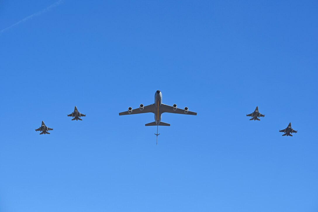 Five aircraft fly in formation as seen from below.