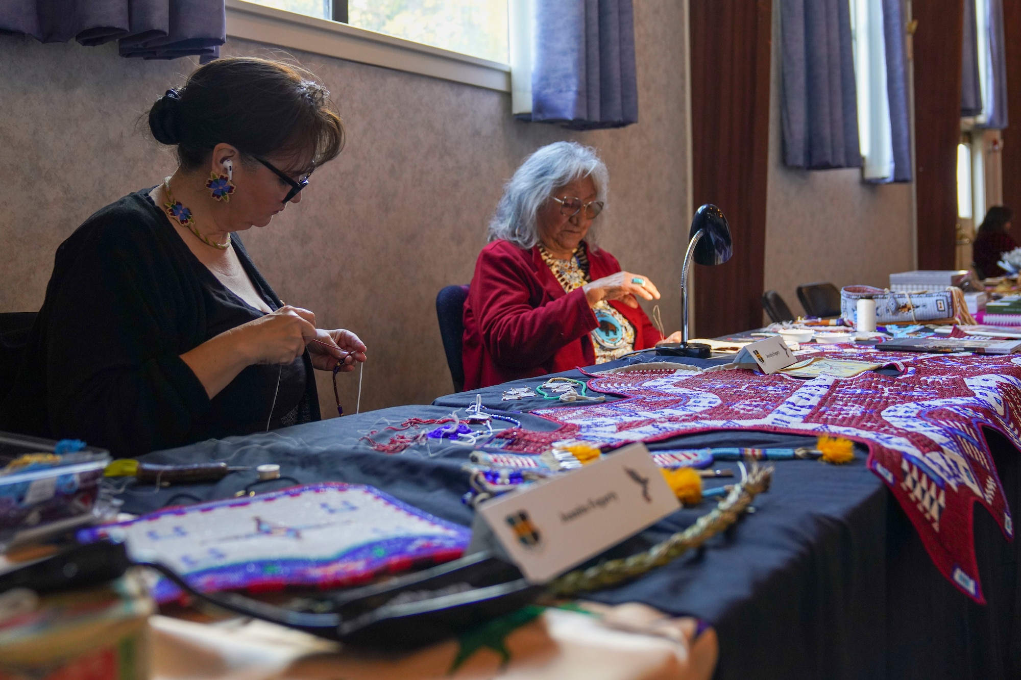 Juanita Fogarty and Joycelyn Fogarty, volunteers, bead jewelry during the Native American Heritage Month event Nov. 16, 2023, at Beale Air Force Base, California.
