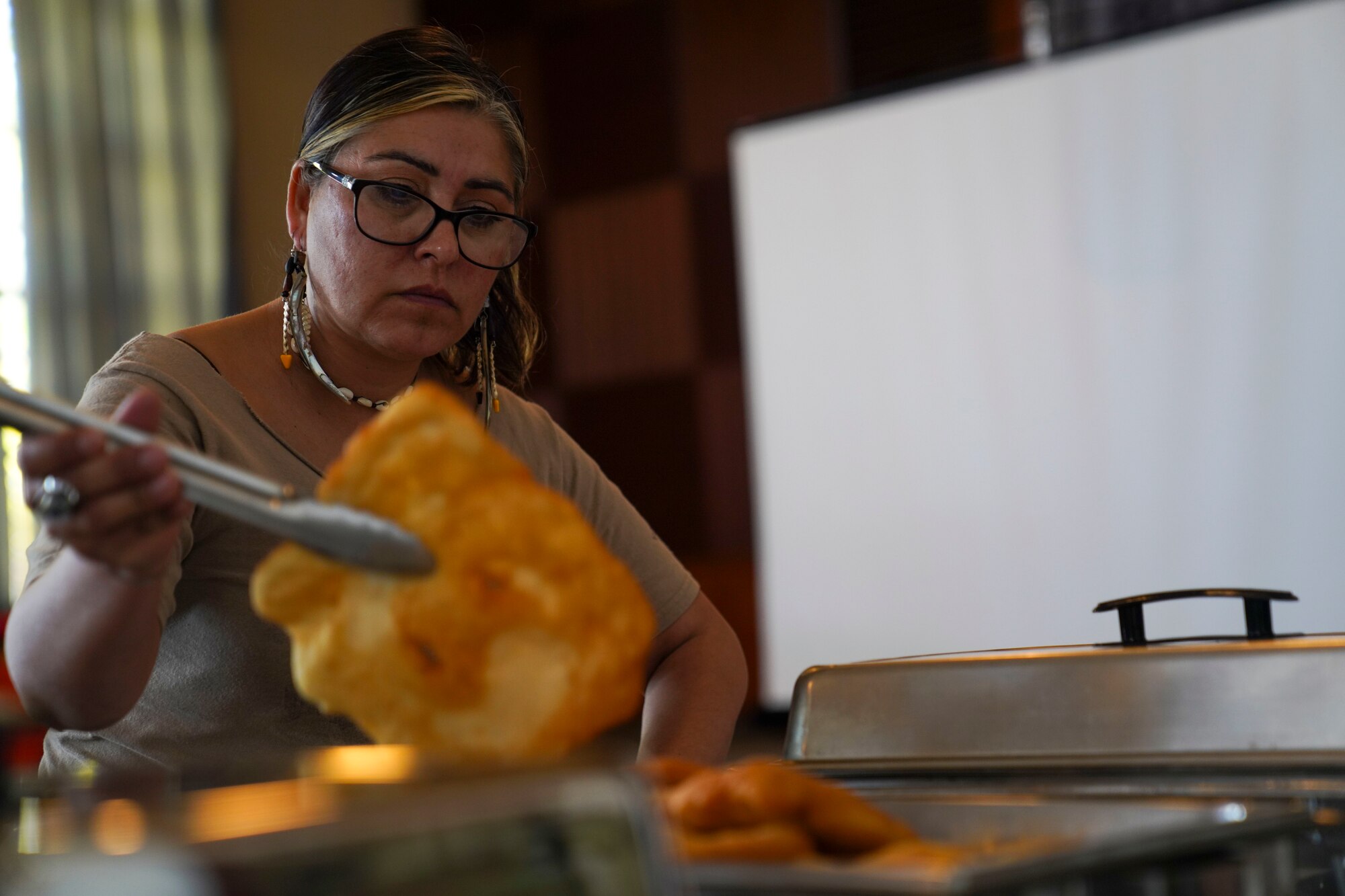 Rita Harvey, volunteer, sets out frybread on display during the Native American Heritage Month event Nov. 16, 2023, at Beale Air Force Base, California.