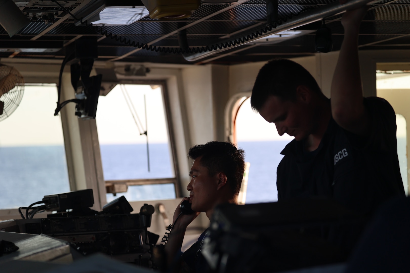 U.S. Coast Guard Lt. j.g. Hongjie Lin, left, directs the steering of Coast Guard Cutter Tahoma (WMEC 908) with Seaman Apprentice Kevin Colbeck at the helm in the Florida Straits, Nov. 6, 2023. Tahoma deployed for a 65-day patrol and conducted maritime safety and security missions while supporting Homeland Security Task Force – Southeast.