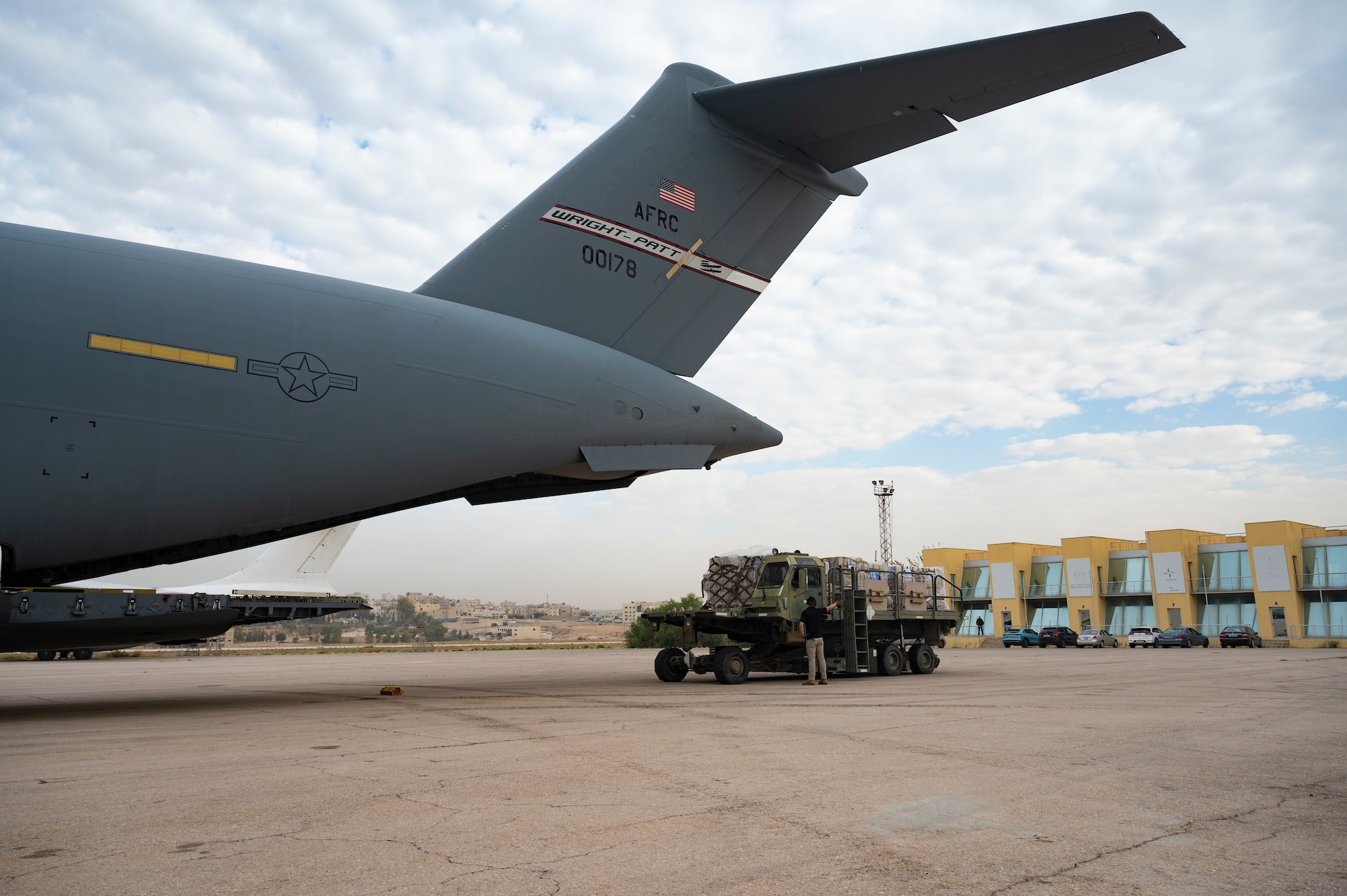 Airmen and USAID personnel load a C-17.