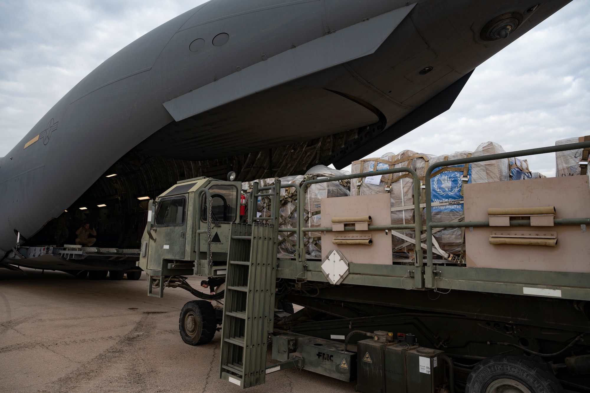 Airmen and USAID personnel load a C-17.