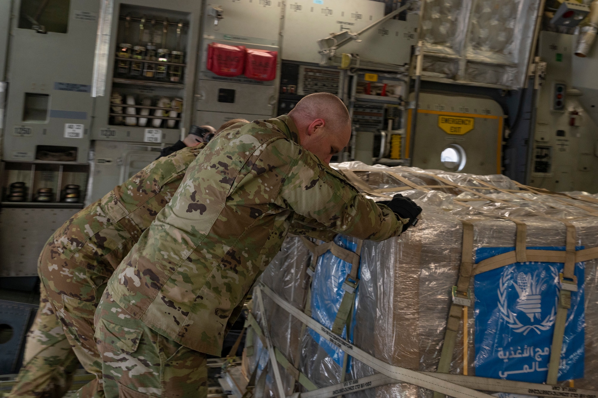 Airmen offload humanitarian aid from a C-17 at an undisclosed airfield in the Middle East.