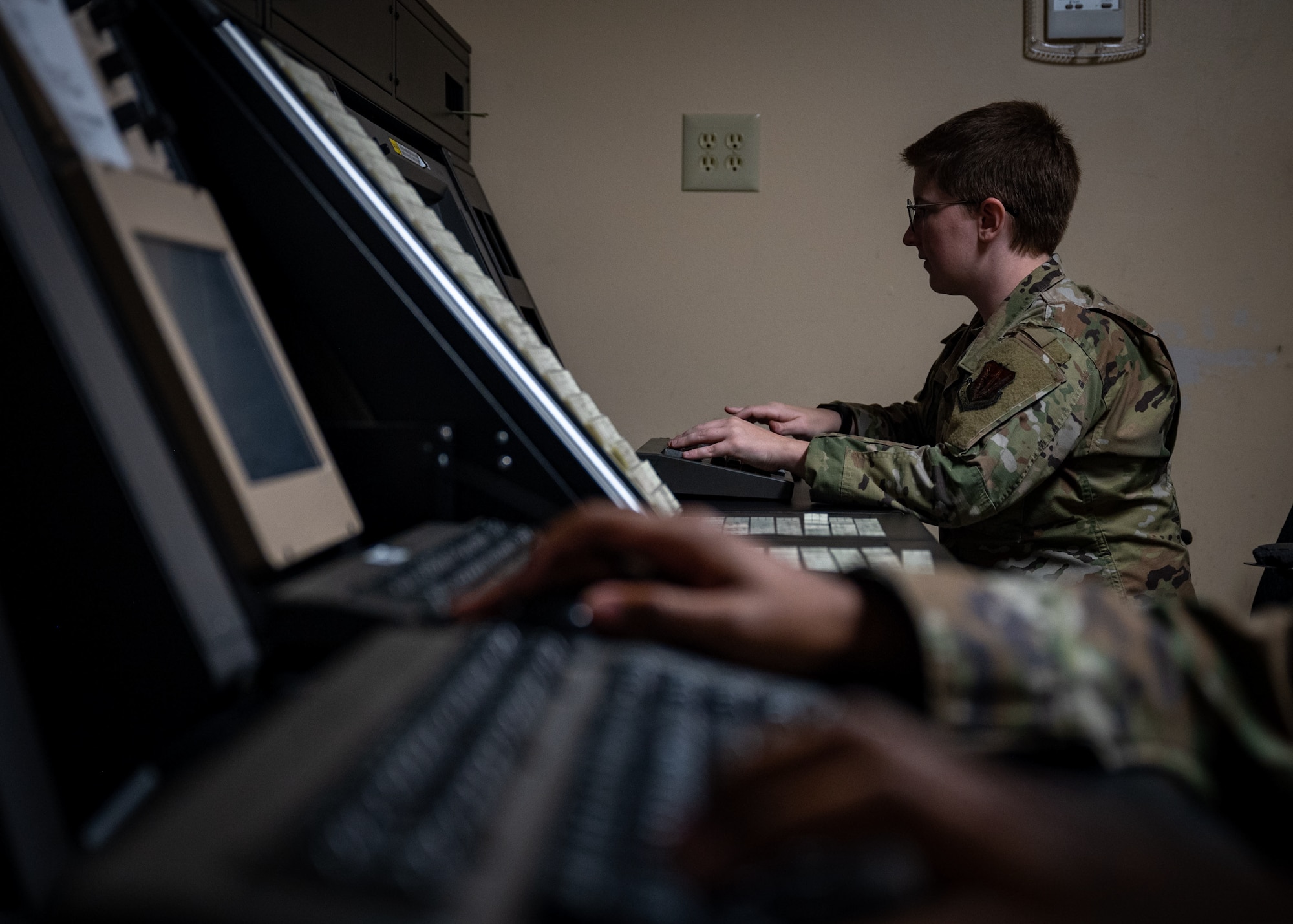 female airman types on keyboard