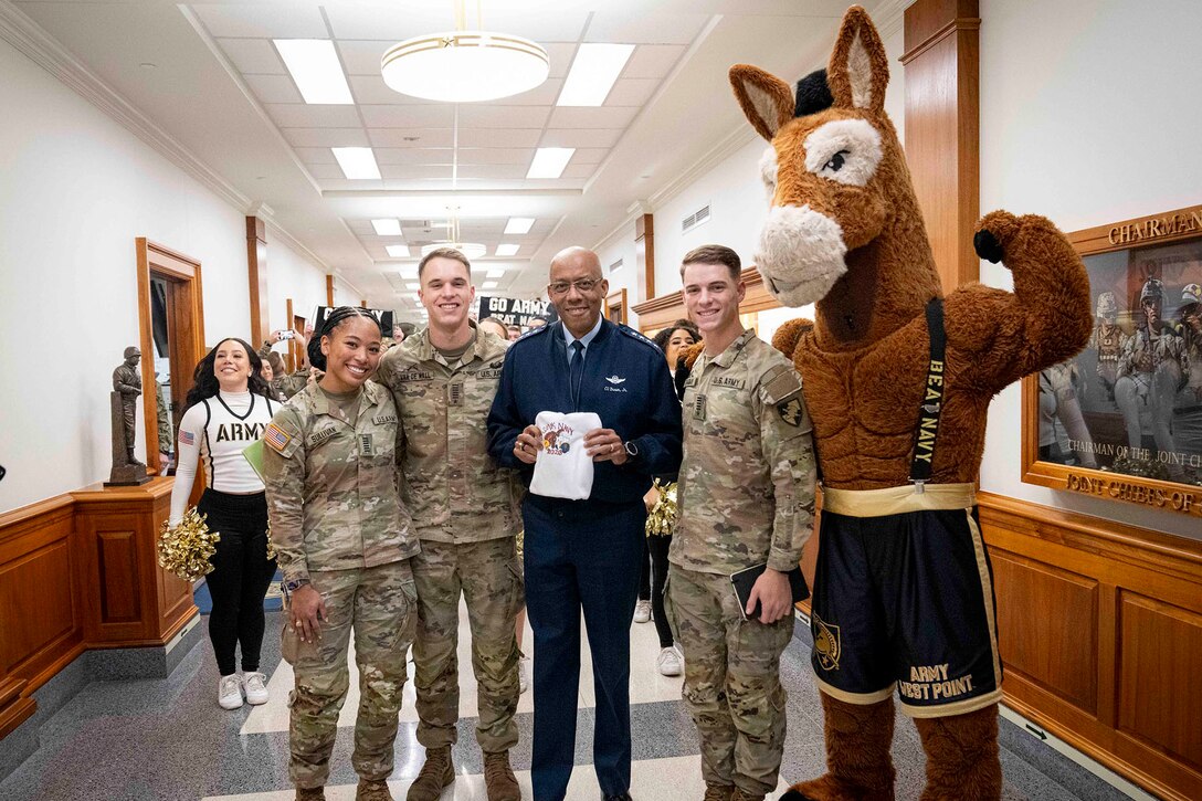 Air Force Gen. CQ Brown, Jr. stands with Army cadets and a mule mascot in a hallway.