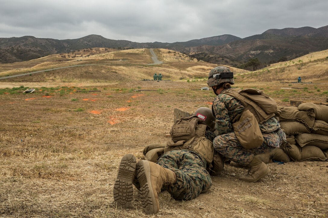 U.S. Marine Corps Sgt. Kathrine E. Cleary, right, combat instructor, School of Infantry (SOI)-West, monitors a Marine Combat Training (MCT) student's line of fire on a rifle range at the Marine Corps SOI-West, Camp Pendleton, Calif., May 18, 2018. MCT gives Marines with Military Occupational Specialties other than Infantry (03xx) a basic understanding of the Marine Corps' warfighting ethos, core values, basic tenets of maneuver warfare, leadership responsibilities, mental, moral, and physical resiliency in order to contribute to the successful accomplishment of their unit's mission. (U.S. Marine Corps photo by Cpl. Hailey D. Clay)