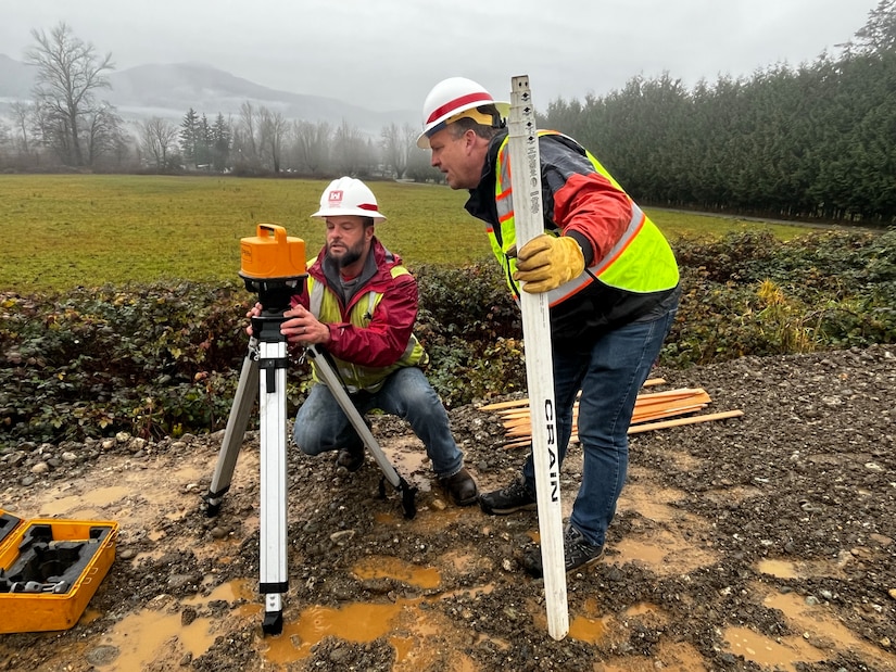 U.S. Army Corps of Engineers flood team members Jeff Wood and Stephen Green work at a levee near Hamilton, Washington, December 5, 2023. USACE is providing direct flood assistance to the City of Hamilton and work began Monday evening to temporarily raise a threatened levee. (U.S. Army photo by Kimberly Lopes)