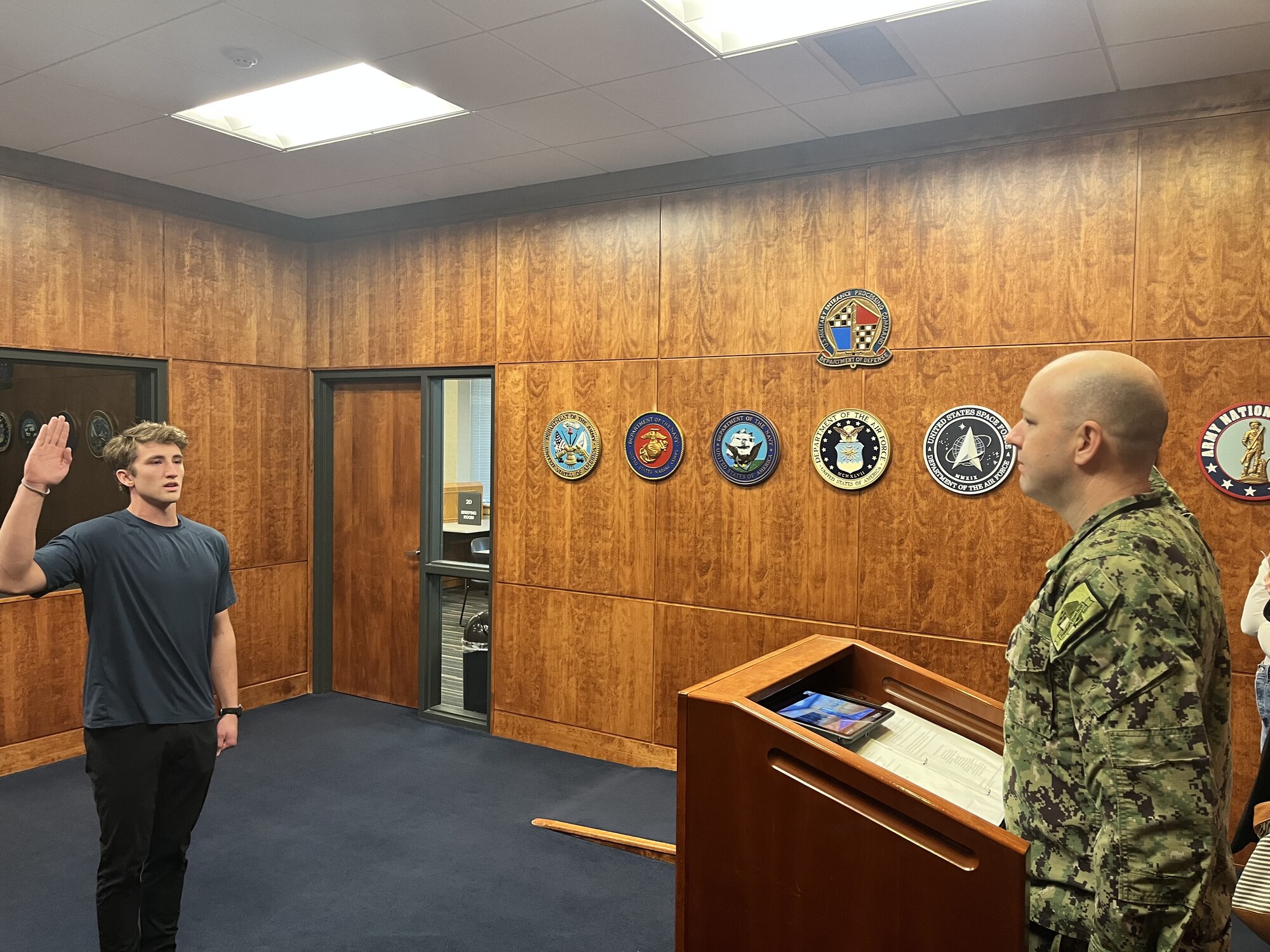 Brennan Cox, a new U.S. Air Force enlisted recruit, recites the oath of enlistment in front of family and friends at the Military Entrance Processing Station in Spokane, Wash., Nov. 14, 2023.