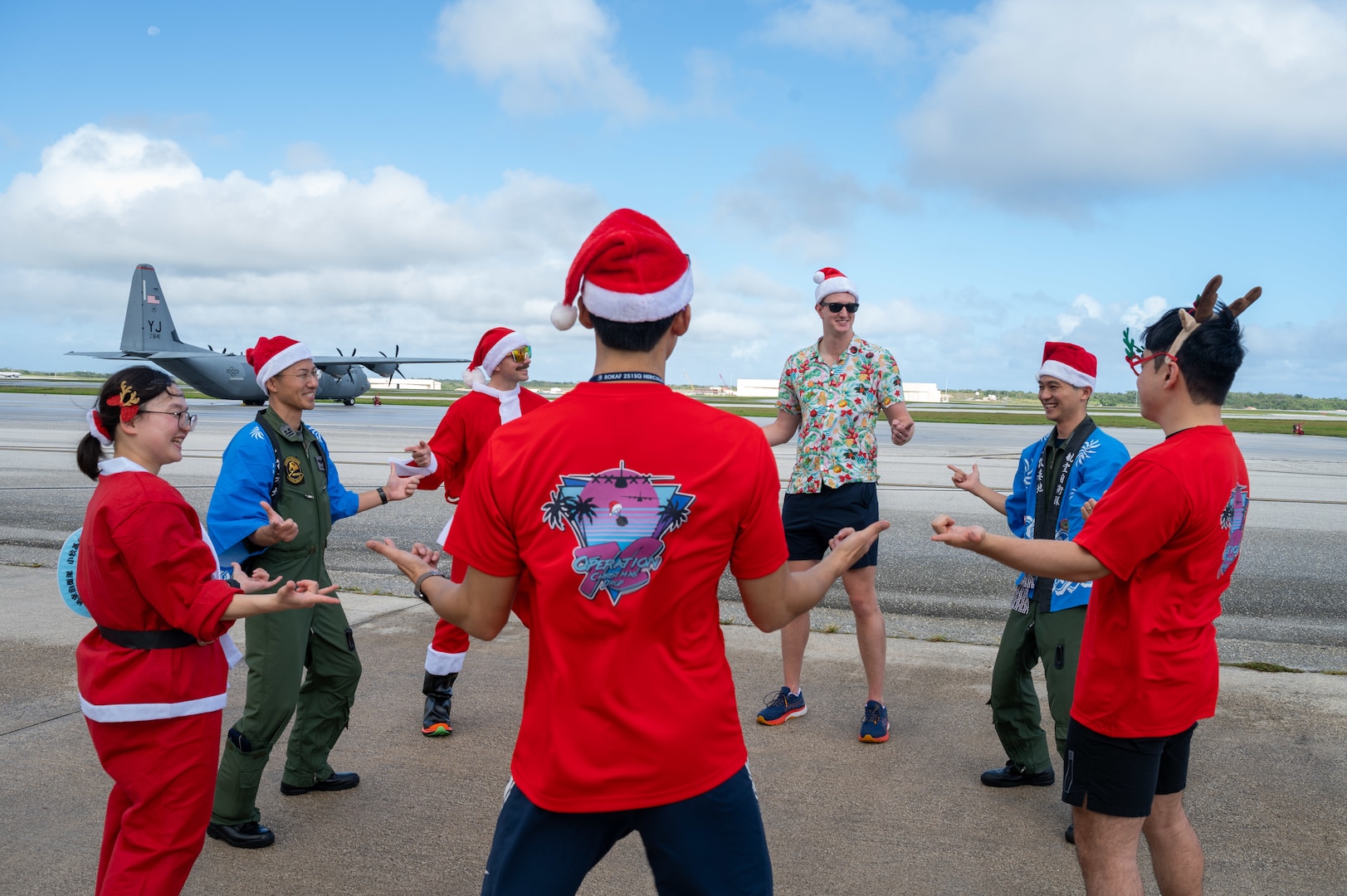 Members of the U.S. Air Force, Japan Air Self-Defense Force, Republic of Korea Air Force, and Royal Australian Air Force point at each other during the annual bundle building event in support of Operation Christmas Drop 2023 (OCD 23) at Andersen Air Force Base, Guam, Dec. 2, 2023. OCD provides an annual opportunity for U.S. and partner nation forces to operate side-by-side to airlift humanitarian aid to remote islands across the Pacific, with this event emblematic of our mutual respect and cooperation with our friends and neighbors. (U.S. Air Force photo by Senior Airman Brooklyn Golightly)