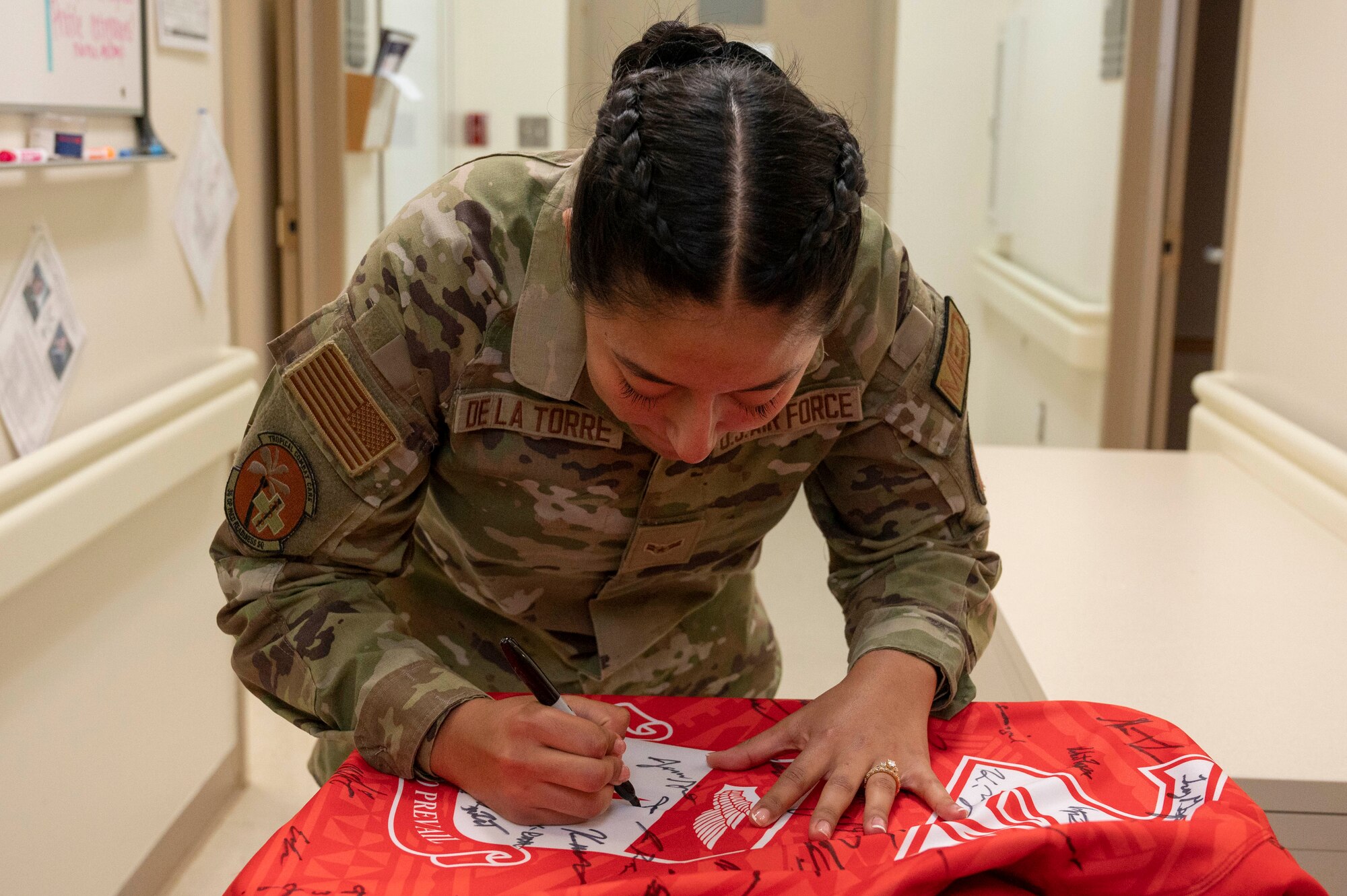 Photo of an Airman signing the official Linebacker of the Week jersey