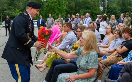 Laura Coppola accepts flowers at the ceremony to dedicate a conference room in honor of her late husband, Fred Coppola, 4 Aug. 2023 at Picatinny Arsenal, NJ.