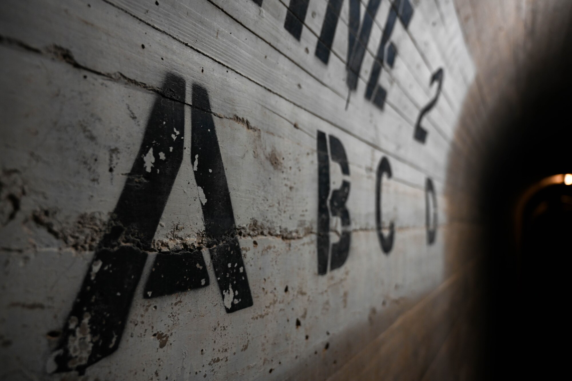 Letters are marked on the wall of the Altus Dam at Lake Altus-Lugert, Oklahoma, Nov. 30, 2023. The dam is 110 feet above its foundation and 1,104 feet long. (U.S. Air Force photo by Senior Airman Trenton Jancze)