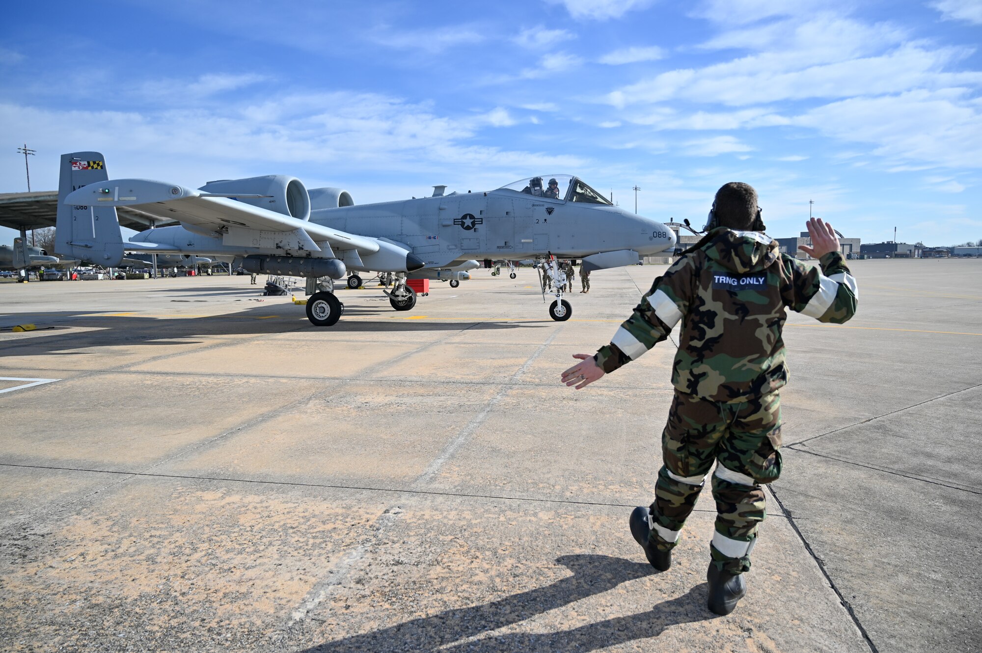A crew chief assigned to the 175th Maintenance Squadron marshals out an A-10C Thunderbolt II aircraft during Operation Frosty Strike Nov. 30, 2023, at Martin State Air National Guard Base, Middle River, Md.