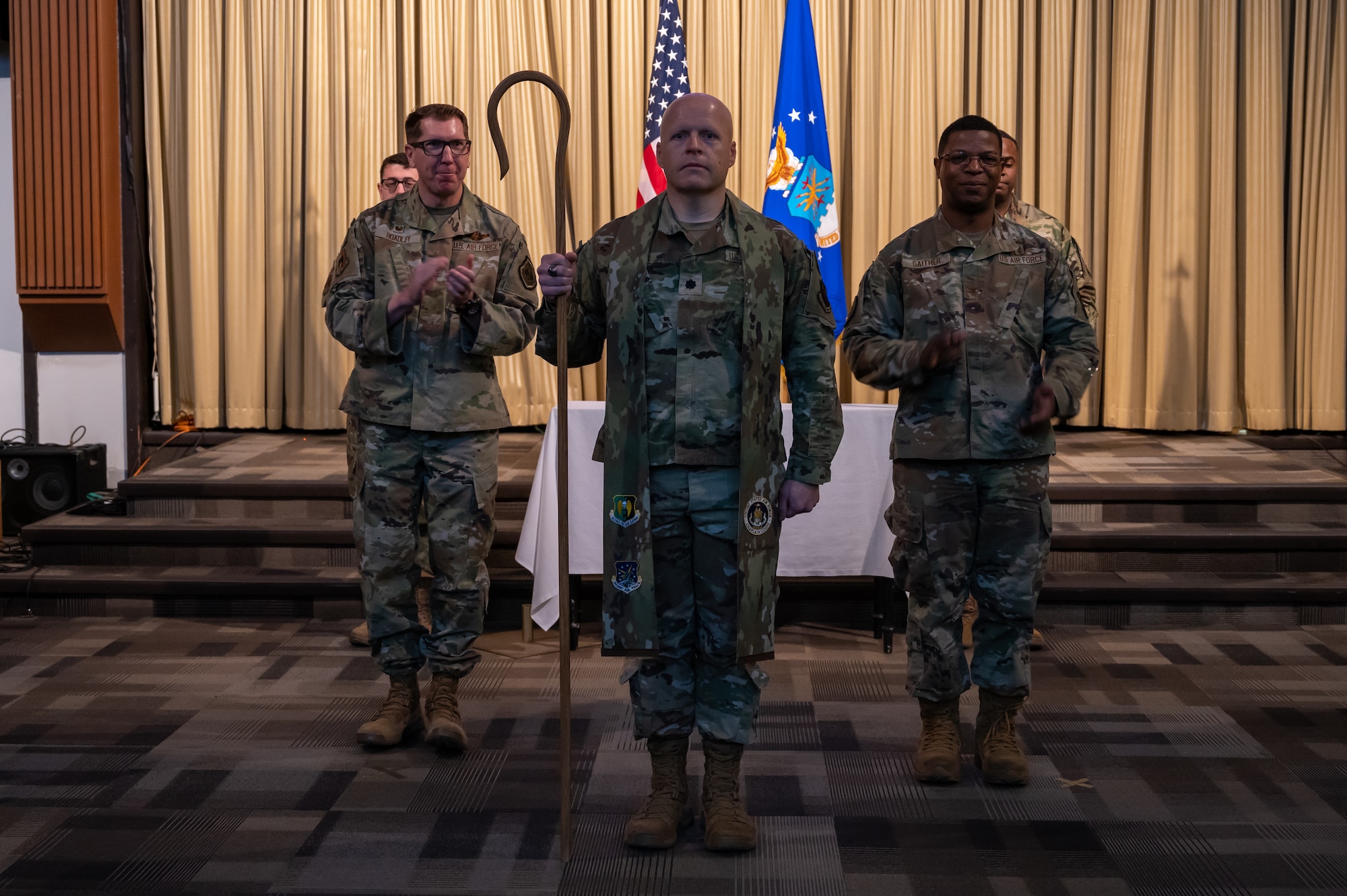 Lt. Col. Ronald Feeser, 5th Bomb Wing command chaplain, stands at attention to assume the stole from Col. Daniel Hoadley 5th Bomb Wing Commander, and Col.Julian Gaither, Air Force Global Strike Command Command chaplain, at Minot Air Force Base, North Dakota, Nov. 30, 2023. The Assumption of Stole Ceremony allows an incoming chaplain to be formally bestowed their role by a senior officer, but instead of a guidon, the new chaplain receives a stole. (U.S. Air Force photo by Airman 1st Class Alexander Nottingham)