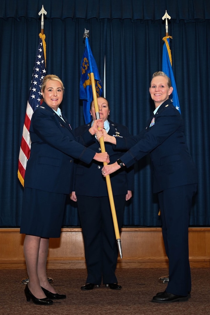 Col. Michelle Van Sickle, 433rd Medical Group commander, presents the 433rd Aeromedical Staging Squadron guidon to Lt. Col. Angella Mudd during an assumption of command ceremony on Joint Base San Antonio-Lackland, Texas, Dec. 2, 2023.