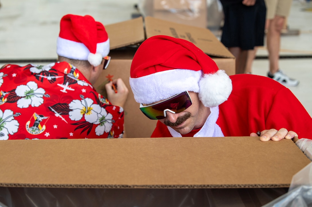 An officer and another airman decorate a bundle box for an event.