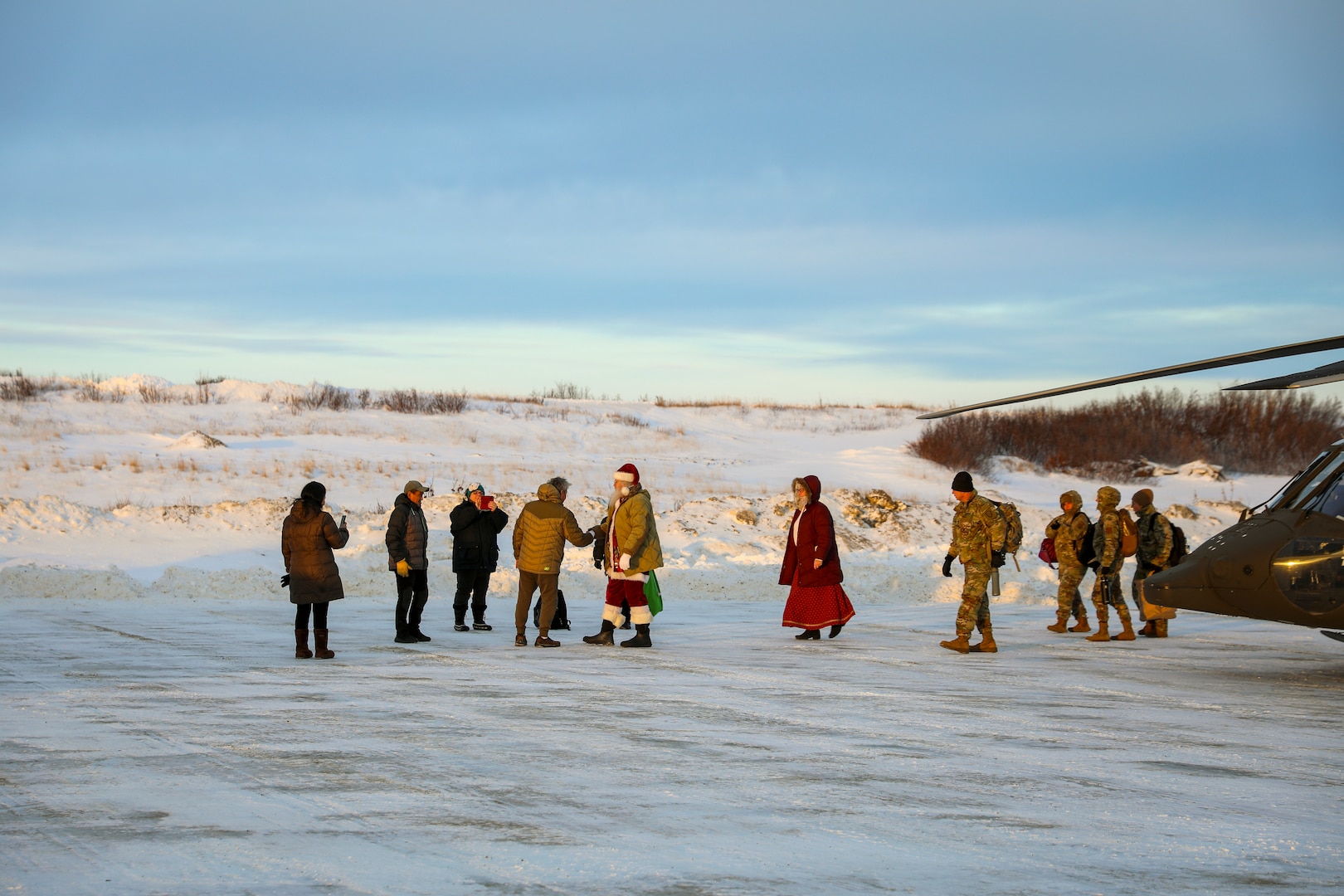 Santa and fellow Operation Santa Claus volunteers greet community members as they exit an Alaska Army National Guard UH-60L Black Hawk near the Inupiat Eskimo village of Golovin Nov. 30, 2023. Operation Santa Claus is the Alaska National Guard’s annual community outreach program that provides gifts and Christmas cheer to children in remote communities.