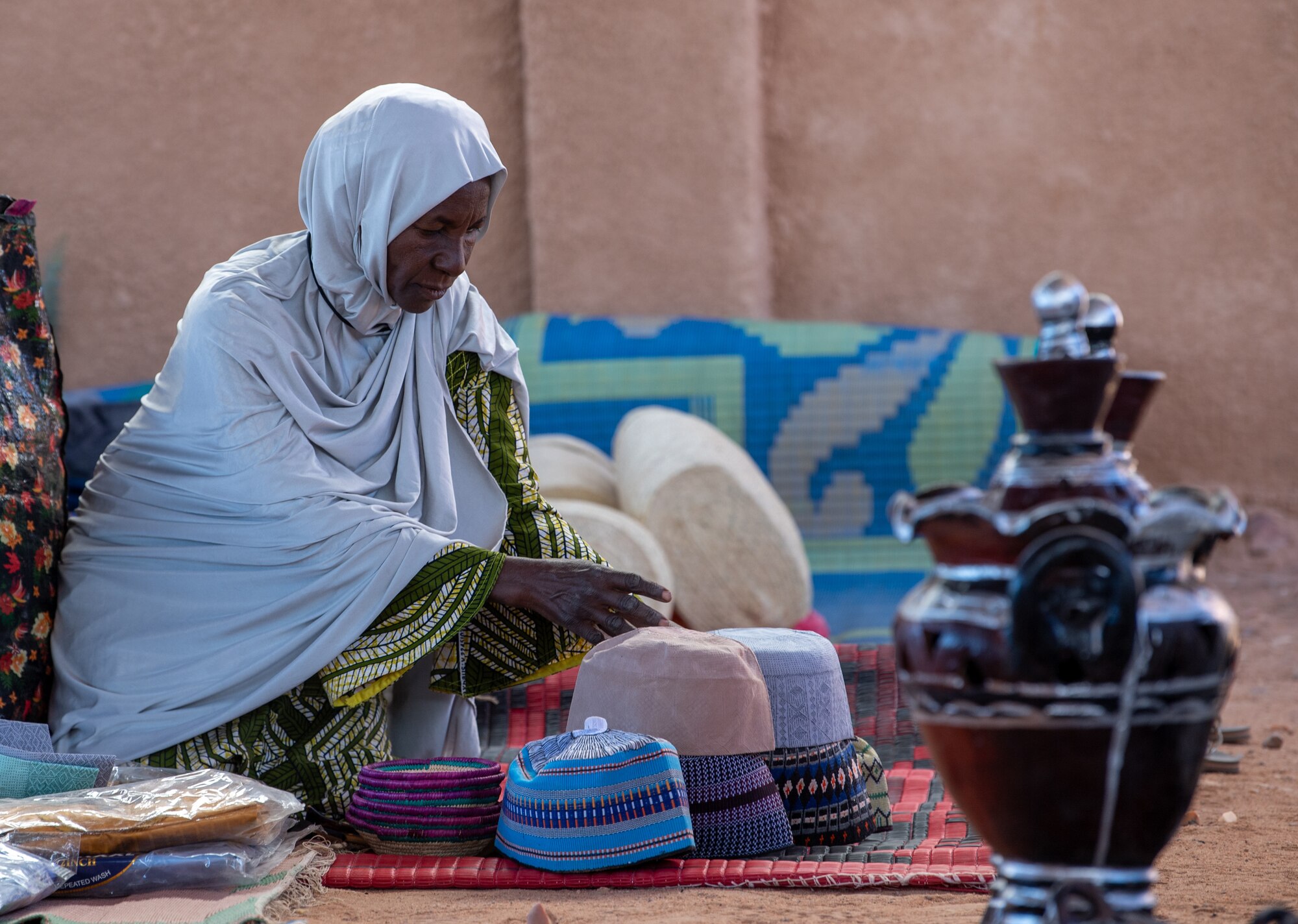A picture of a woman and her handmade items for sale.