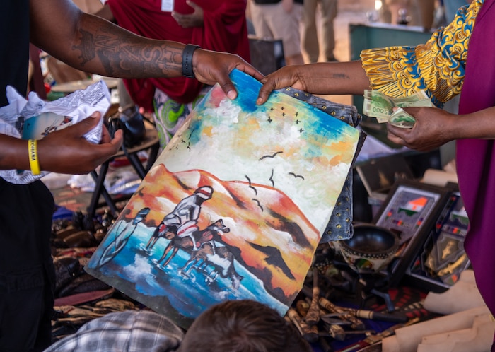 A member buys a painting from a vendor.