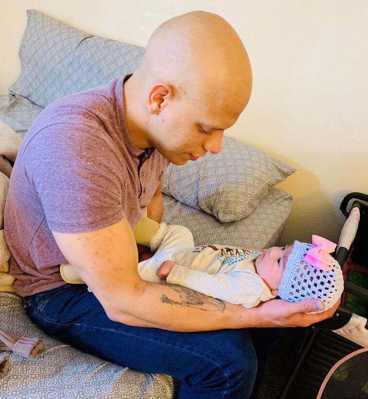 Staff Sgt. Marti holds his infant daughter Isabella.