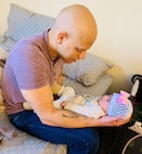 Staff Sgt. Marti holds his infant daughter Isabella.