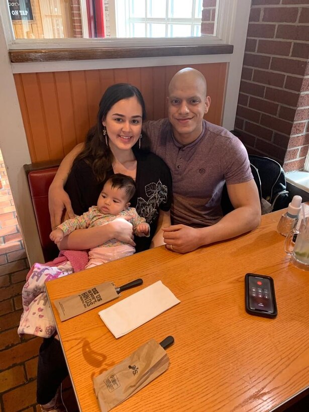 Staff Sgt. Marti sits with his wife and young daughter in a restaurant.