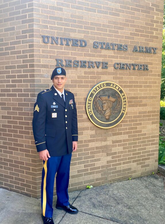 Staff Sgt. Marti stands in front of a U.S. Army Reserve Center sign.