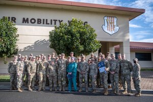 A group of Airmen gather for a photo outside of a building.