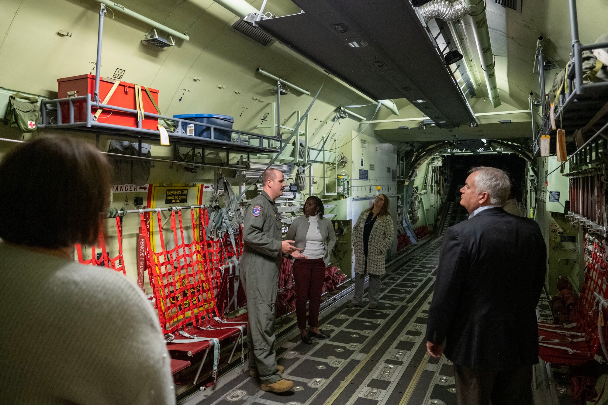 People stand inside a C-130 aircraft.