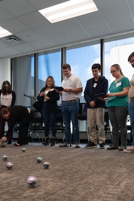 ANNAPOLIS, Md. (Nov. 28, 2023) - Naval Ordnance Test Unit Associate Chief Engineer Leslie Amodeo (far right) programs and operates a Sphero BOLT Coding Robot during a U.S. Naval Academy (USNA) Science, Technology, Engineering and Math (STEM) during a computational thinking seminar at the USNA Tuesday, November 28. Nested under Strategic Systems Programs Strategic Weapons Facility-Atlantic and NOTU employees attended the day-long workshop--hosted by USNA's STEM Center for Education and Outreach and sponsored by the DoD and the Office of Naval Research--to learn about new and successful tactics, curriculum, and methods for STEM outreach at schools in local communities across the nation. (U.S. Navy Photo by Lt. Jennifer Bowman/Released)