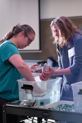 ANNAPOLIS, Md. (Nov. 28, 2023) - Naval Ordnance Test Unit (NOTU) Associate Chief Engineer Leslie Amodeo (left) and Strategic Weapons Facility-Atlantic (SWFLANT) Process Improvement Coordinator Caren Spahr (right) participate in a buoyancy test during the U.S. Naval Academy (USNA) Science, Technology, Engineering and Math (STEM) workshop Tuesday, November 28. Nested under Strategic Systems Programs, STEM leads from SWFLANT and NOTU attended the day-long workshop--hosted by USNA's STEM Center for Education and Outreach and sponsored by the DoD and the Office of Naval Research--to learn about new and successful tactics, curriculum, and methods for STEM outreach at schools in local communities across the nation. (U.S. Navy Photo by Lt. Jennifer Bowman/Released)