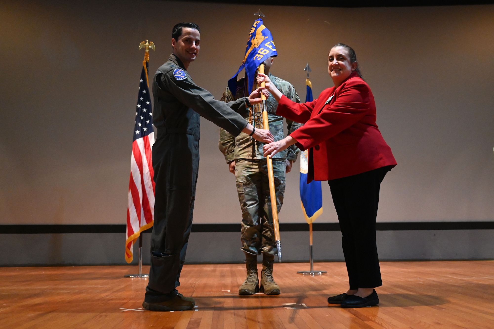 U.S. Air Force Lt. Col. David Criscione, 36th Electronic Warfare Squadron commander, inducts Maureen Bierman, Director of Marketing and External Affairs for Step One Automotive Group and serves as the Chairperson of The board of directors of the Greater Fort Walton Beach Chamber of Commerce, during the wing’s first Honorary Commander Induction ceremony, at Eglin Air Force Base, Fla., Dec. 1, 2023. Honorary Commanders serve as the liaison between the 350th Spectrum Warfare Wing and the surrounding community by maintaining strong relations through mutually beneficial professional partnership. (U.S. Air Force photo by Staff Sgt. Ericka A. Woolever)