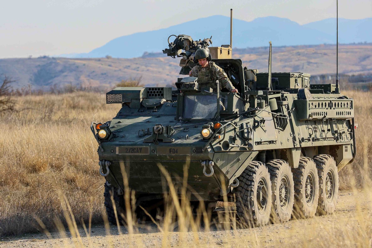 A soldier travels in a military vehicle.