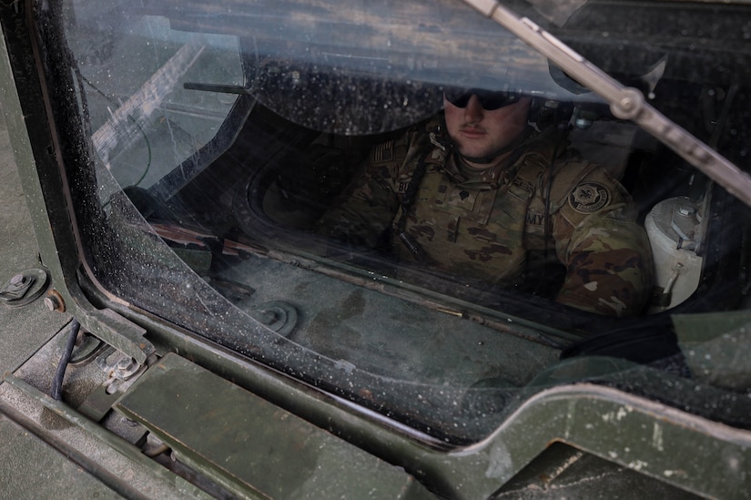 A soldier sits in a military vehicle.