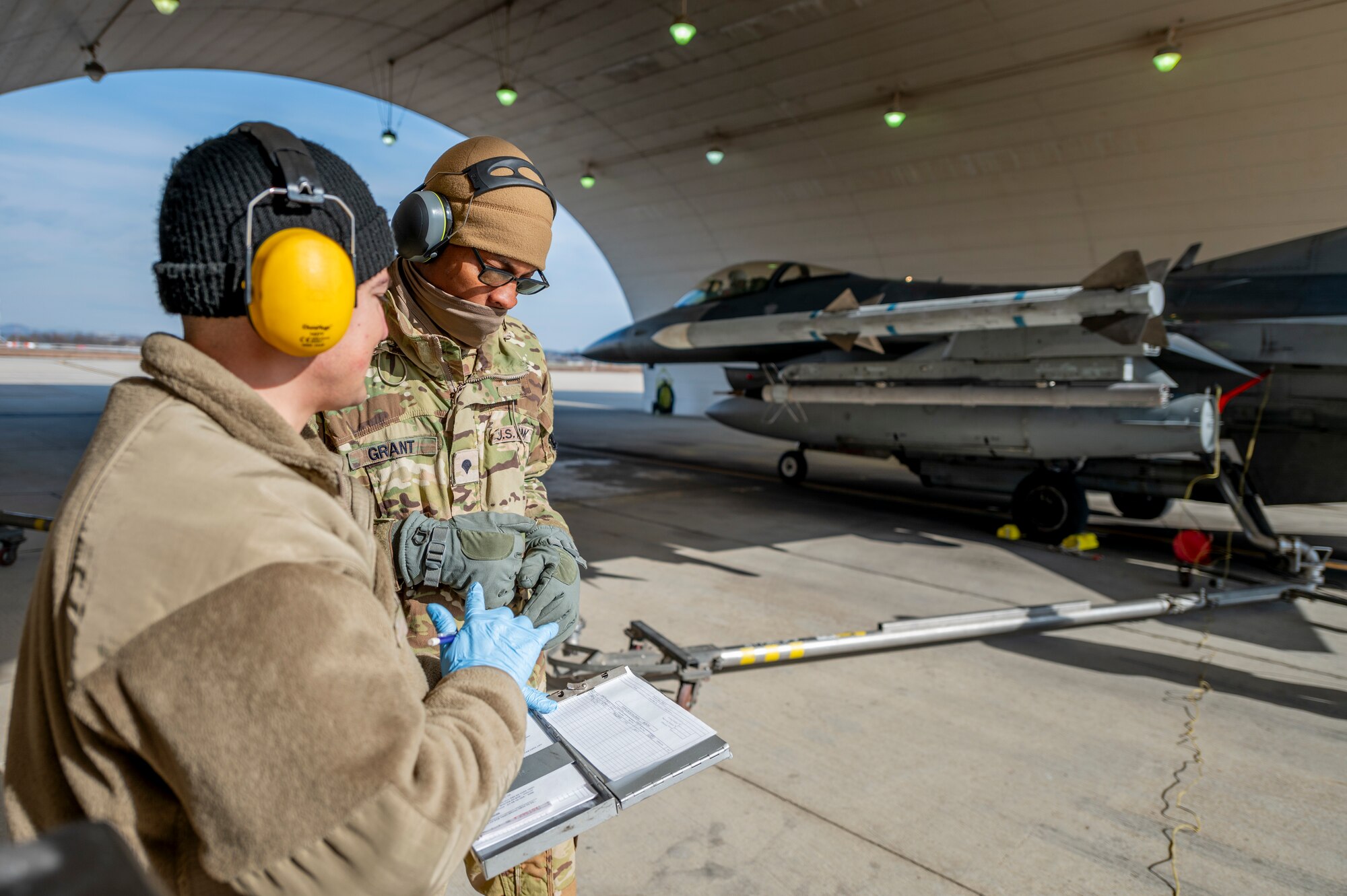 U.S. Air Force Staff Sgt. Antonio Rios, 51st Logistics Readiness Squadron fuels distribution supervisor, and U.S. Army Spc. Marcus Grant, 2nd Infantry Division Sustainment Brigade petroleum supply specialist, review a checklist during an F-16 Fighting Falcon hot-pit refuel at Osan Air Base, Republic of Korea, Nov. 29, 2023.