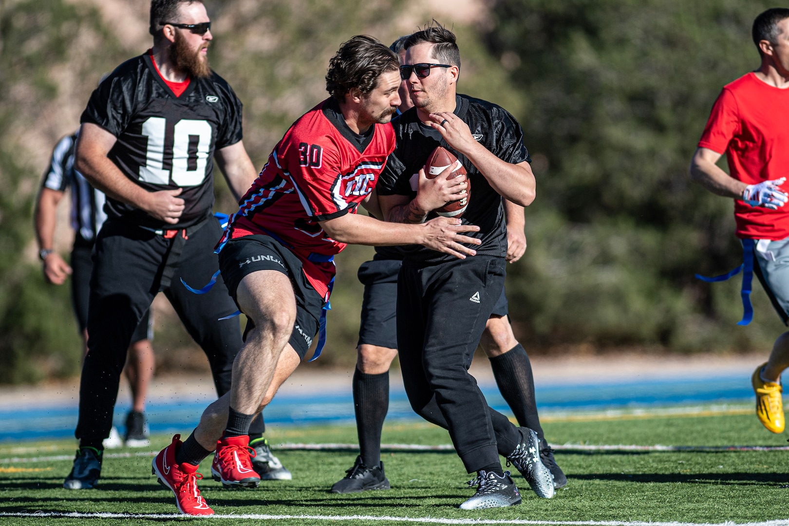 Man tackles other man holding football