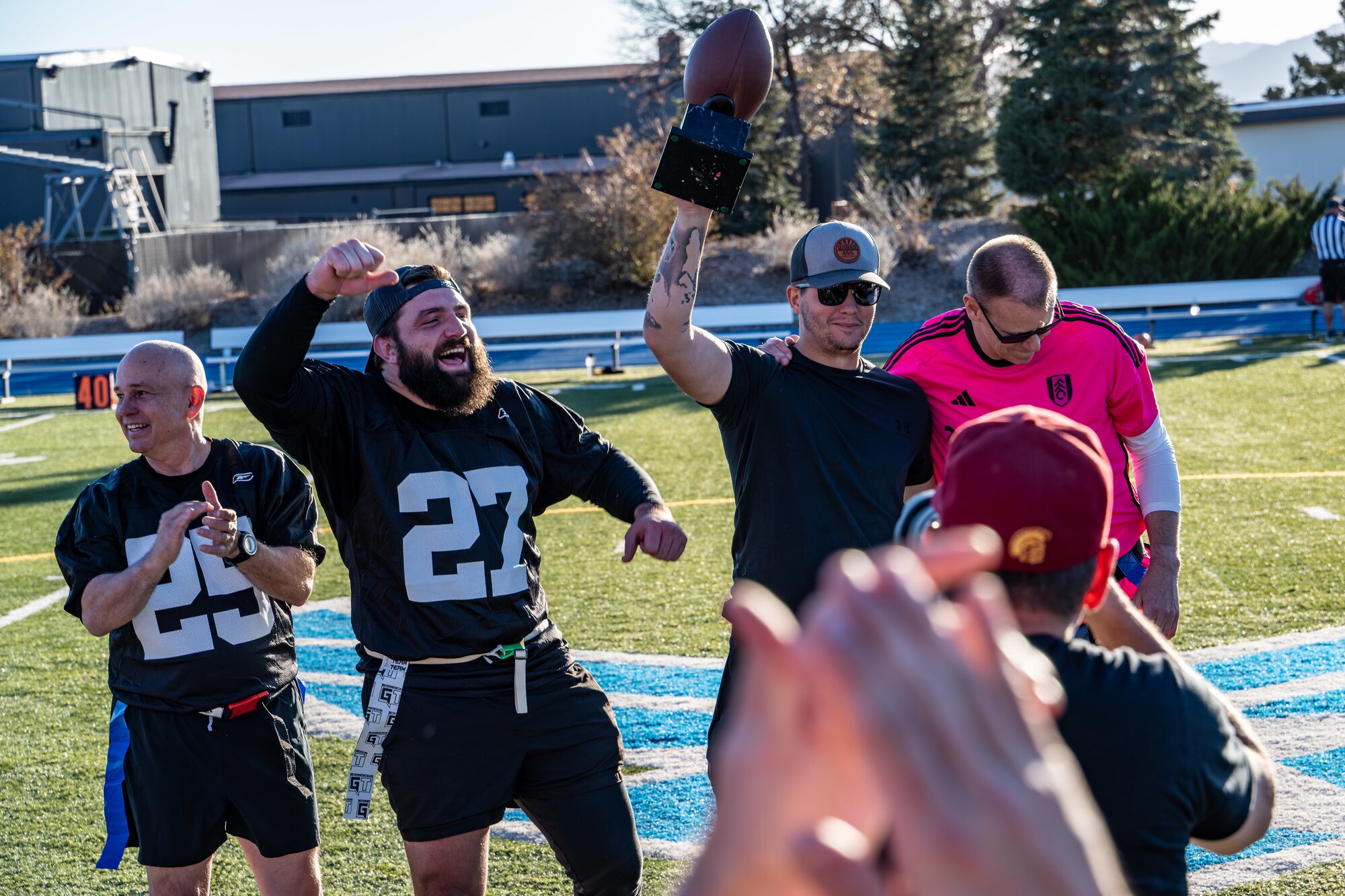 Member holds up trophy next to teammates