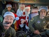 Alaska Air National Guard pilots 1st Lt. Skylar Caldwell, left, and Capt. Gerren Blair, and loadmaster, Tech Sgt. John Teamer II, enjoy time with Santa and Mrs. Claus while flying the festive couple to Bethel during Operation Santa Claus Nov. 15, 2023.