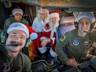 Alaska Air National Guard pilots 1st Lt. Skylar Caldwell, left, and Capt. Gerren Blair, and loadmaster, Tech Sgt. John Teamer II, enjoy time with Santa and Mrs. Claus while flying the festive couple to Bethel during Operation Santa Claus Nov. 15, 2023.