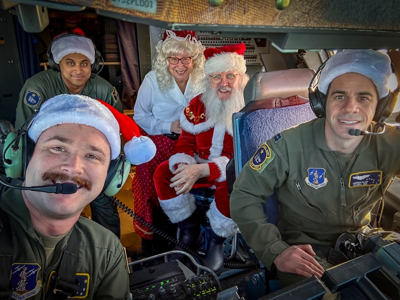 Alaska Air National Guard pilots 1st Lt. Skylar Caldwell, left, and Capt. Gerren Blair, and loadmaster, Tech Sgt. John Teamer II, enjoy time with Santa and Mrs. Claus while flying the festive couple to Bethel during Operation Santa Claus Nov. 15, 2023.