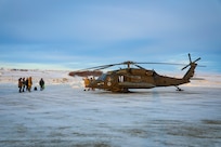 Santa and fellow Operation Santa Claus volunteers greet community members as they exit an Alaska Army National Guard UH-60L Black Hawk near the Inupiat Eskimo village of Golovin, Nov. 30, 2023.