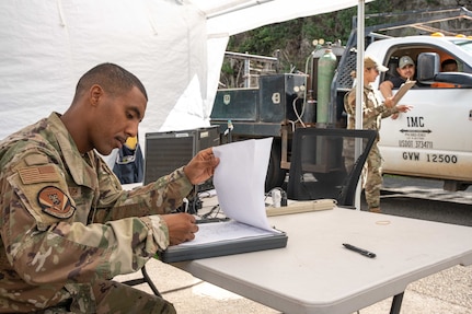 Joint Task Force-Red Hill (JTF-RH) Access Control Point team members, Tech. Sgt. Samuel Yarbrough Jr. and Senior Airman Lerishane Enriquez monitor personnel at Red Hill Bulk Fuel Storage Facility (RHBFSF), Halawa, Hawaii, Dec. 4, 2023.